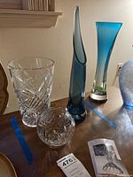 Overview of lot including cobalt blue blown glass vase, flared top crystal vase, clear cut crystal cylinder vase, round crystal bud vase