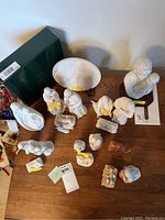 Overview of various white porcelain and ceramic nativity figures including a dark green box and certificates.