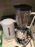 Photo showing Jet Blend blender with chrome base and clear plastic jar, Toastmaster white electric kettle, and Black & Decker black two slice toaster in background.