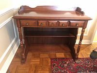Front angle showing full wooden Vilas Captain's desk with four drawers, turned legs, raised back panel, and lower shelf.