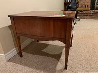 Side and back view showing tapered legs and wood grain.