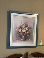 Full view of the framed floral painting on a wall.