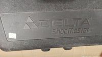 Closed black plastic carrying case embossed with Delta ShopMaster logo