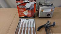 Betty Crocker popcorn maker box, Cuisinart rice cooker, Sabatier steak knife set in packaging, Persona vegetable scissors