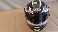 Front view of Gmax full-face motorcycle helmet showing black and white distressed paint finish and clear visor down.