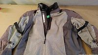 Front view of Oxford padded motorcycle jacket in two-tone gray with mesh panels and zipper closure.