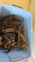 Blue bin filled with assorted old wooden hand planes showing wear and rust.