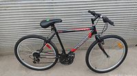 Full side view of the black, red and silver Supercycle 26-inch boys mountain bike showing frame, tires, handlebars, and saddle.
