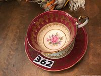 Overhead image showing interior floral design of the teacup and matching decorated saucer with visible lot number 362