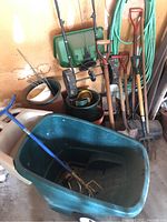 Garden cart full view showing handle and wheels with blue cultivator inside