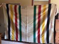 Full view of blanket showing multicolour stripes and embroidered border