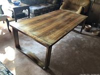 Side angle showing overall wood grain surface and curved leg design of the coffee table in a living room setting.