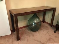 Angle view of the Parsons table showing rosewood legs and copper top surface with natural patina.