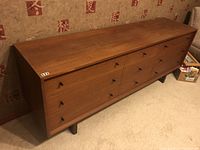 Front perspective view of nine-drawer dresser showing full front and legs