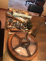 Photo showing teak lazy susan with clear glass appetizer tray, serving tools, and place mats arranged on table.