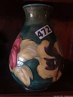 Front view showing yellow and red hibiscus blossoms against green glaze