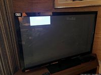 Front view of Panasonic 42-inch plasma TV turned off with reflections on the screen and some background visible.