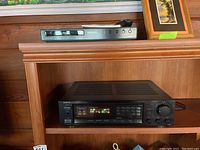 Onkyo TX-800 tuner amplifier and Philips DVP 3570 DVD player on wooden shelf.