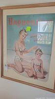 Full framed vintage poster showing woman and child in bathing suits on a sandy background with 'Unguentine' text