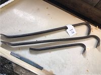 Top view of three metal crow bars laid out on a flat surface showing relative sizes and shapes