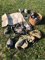 Overview of duck decoys, bags, and duck call arranged on grass showing wear and paint on decoys.