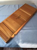 Closed view of the wooden case showing Newbridge Cuisine branding and exterior condition.