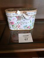 Decorative floral storage box with ribbon bow on lid shown closed