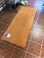 Full top view of a rectangular wood coffee table with curved edges, showing overall condition and shape.