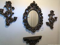 Full view showing the wall mirror, shelf, and two candle holders arranged on wall.