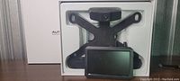 Photo of new AutoVox car back up camera system showing a black license plate holder with attached waterproof camera and the separate dashboard screen in packaging.