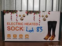 Front of box showing product name, usage benefits including washable, breathable, keep warm, absorbent, and a picture of the heated socks.