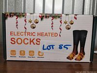 Box front showing product name 'Electric Heated Socks' and icons indicating washable, breathable, keep warm, and absorbent features.