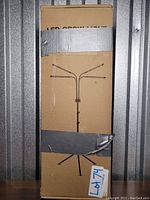 Front view of the boxed multi-headed LED grow light showing taped cardboard with product illustration and lot number label.