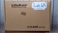Sealed cardboard box labeled LiitoKala Intelligent Battery Charger with compliance markings and Lot 64 sticker.