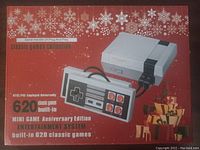 Photo of the unopened box of the mini game anniversary edition entertainment system showing front design highlighting 620 classic games and the controllers.