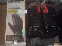 Gloves displayed next to original packaging showing front and back design including padding and wrist straps.