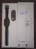 Box containing a black silicone TranyaGo smart watch with accompanying USB charging cable, showing front of packaging and watch inside.