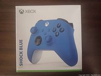 Front view of the Xbox controller box showing the Shock Blue color controller and product branding.