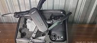 Foldable drone with camera folded and placed in protective black foam case.