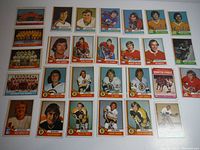 Top-down image showing multiple 1974-75 O-Pee-Chee NHL hockey cards laid out flat, including player portraits and team photos.