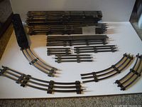 All metal 3 rail tracks laid out on flat surface, showing straight and curved sections, total 35 pieces