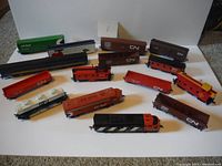 Overview photo showing most of the lot laid out on a white surface, displaying various colored HO scale train cars predominantly in CP Rail and CN liveries.