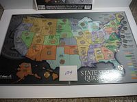 Full view of the large map display book with each US state quarter embedded on the map correlating with the state.