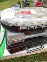 Stacked carrying cases with clear plastic lid showing accessory bits inside.