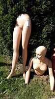 Full view of vintage mannequin torso and separate legs outdoors on grass, showing overall wear and tear.