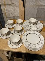 Full set showing cups, saucers, dinner and salad plates arranged on table.