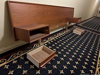 Front view of full headboard mounted with two floating side table drawers and removed drawer fronts on carpeted floor