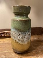 Full front view of the ceramic vase showing the green to brown drip glaze pattern.