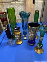 Seven assorted crystal and Bohemian style vases arranged together showing variety of colors and sizes