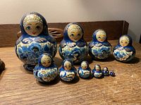 Full set of 10 blue hand-painted wooden nesting dolls arranged from largest to smallest.